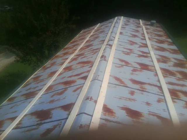 Rusted metal roof panels with new wood purlins before replacement — Storm Damage Roof Repair in Aplington by Roofing Brothers